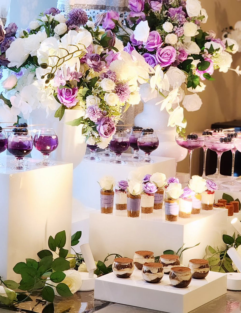 Elegant dessert table with white and purple floral arrangements